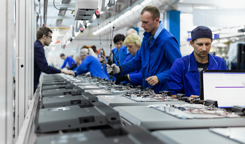 Workers on the conveyor for the production of computers.