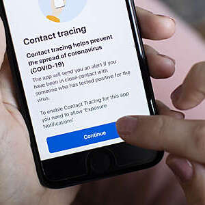 The UK governments new test and trace application is displayed on a handheld device.